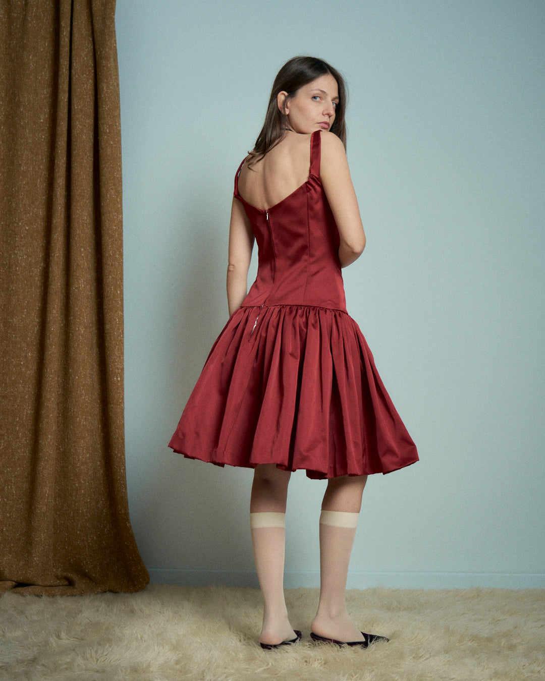 Abito in raso rosso con bustino e gonna arricciata