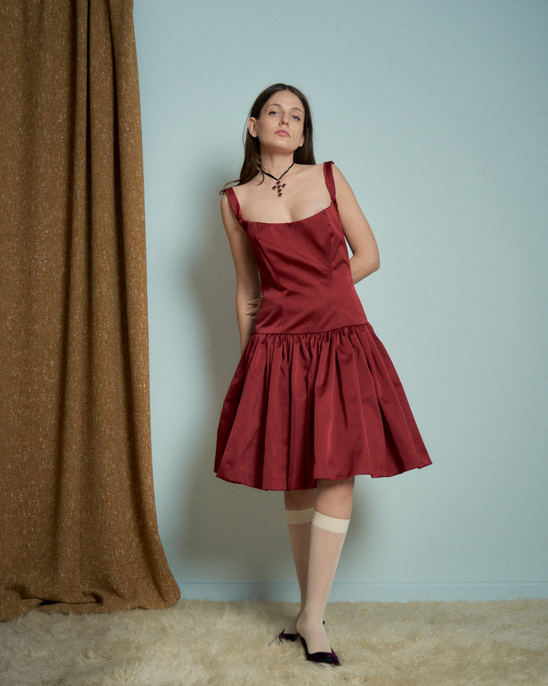 Abito in raso rosso con bustino e gonna arricciata