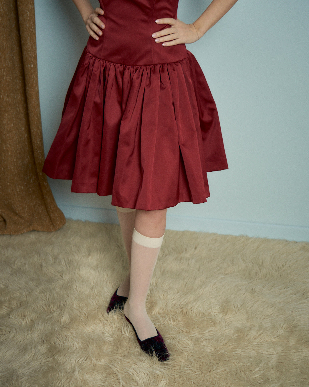 Abito in raso rosso con bustino e gonna arricciata