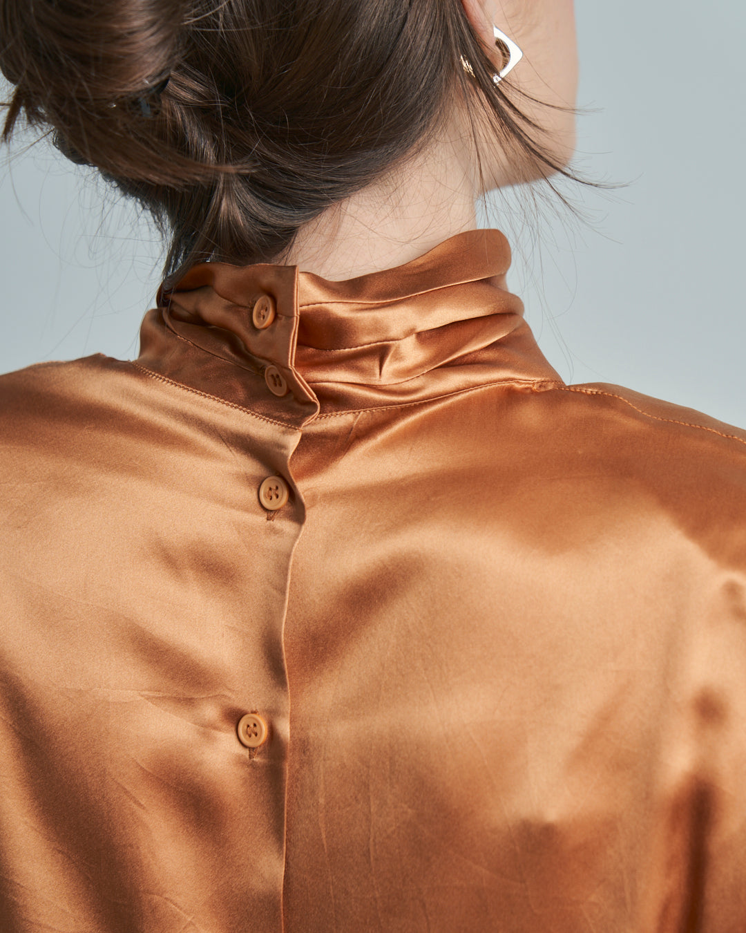 Blusa Albicocca in seta con collo alto incrociato e bottoni sul retro
