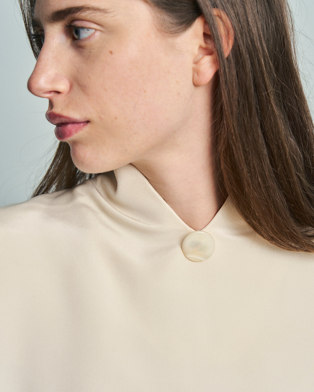 Blusa in seta sartoriale anni 80 avorio collo alto a V e apertura sul retro